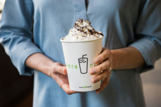 Holding a Chocolate Cookies & Cream shake.