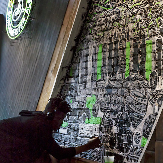 Artist drawing on brick wall