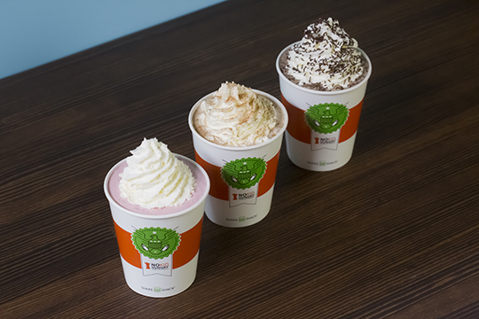 Three shake shack shakes lined up in a row on top of a table