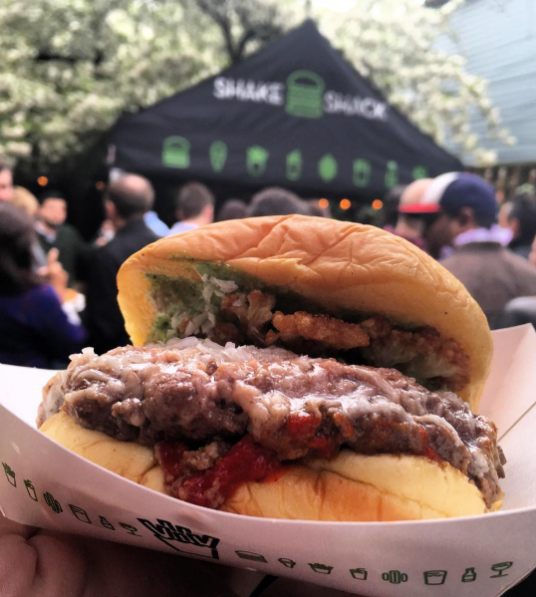 Shake Shack and Chef Lee Wolen's BOKA inspired burger in front of Shake Shack booth