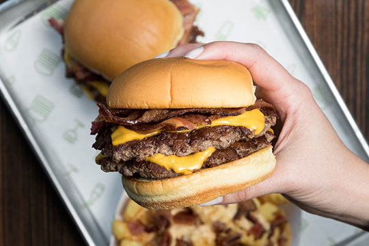 Bacon Double Cheeseburger held in hand