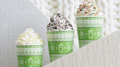 three shakes with different toppings, in green holiday themed cups